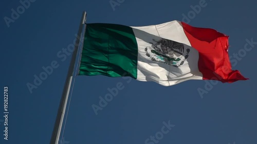 Slow motion of back lit Mexican flag waving in the wind. photo