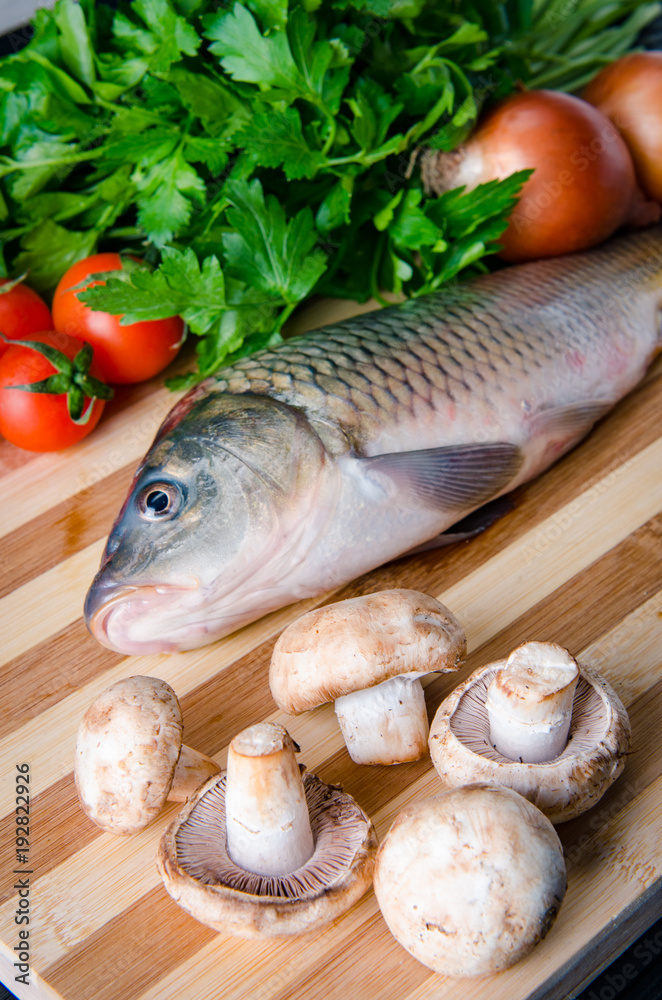 Uncooked fish on cutting board in meal preparation concept Uncooked fish on cutting board in meal preparation concept