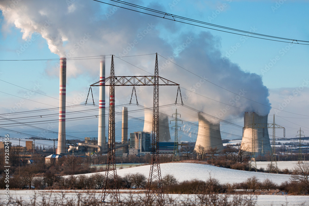 A coal-fired power station in the distance in agricultural landscape. Pocerady, Czech republic A coal-fired power station in the distance in agricultural landscape. Pocerady, Czech republic