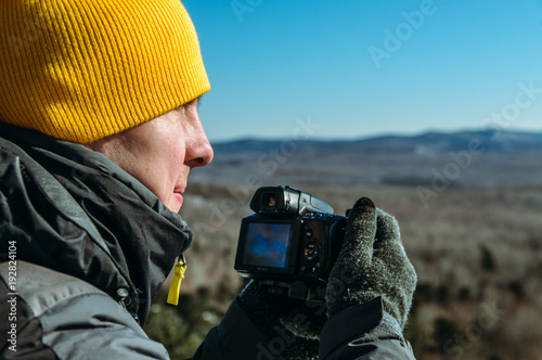 photographer naturalist at work in winter on top of the mountain photo