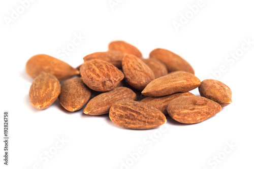 heap of brown roast almonds on white background