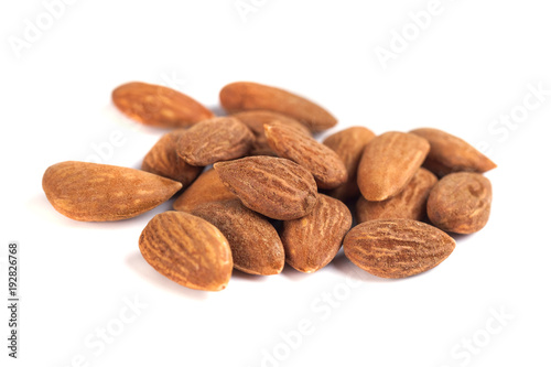 heap of brown roast almonds on white background
