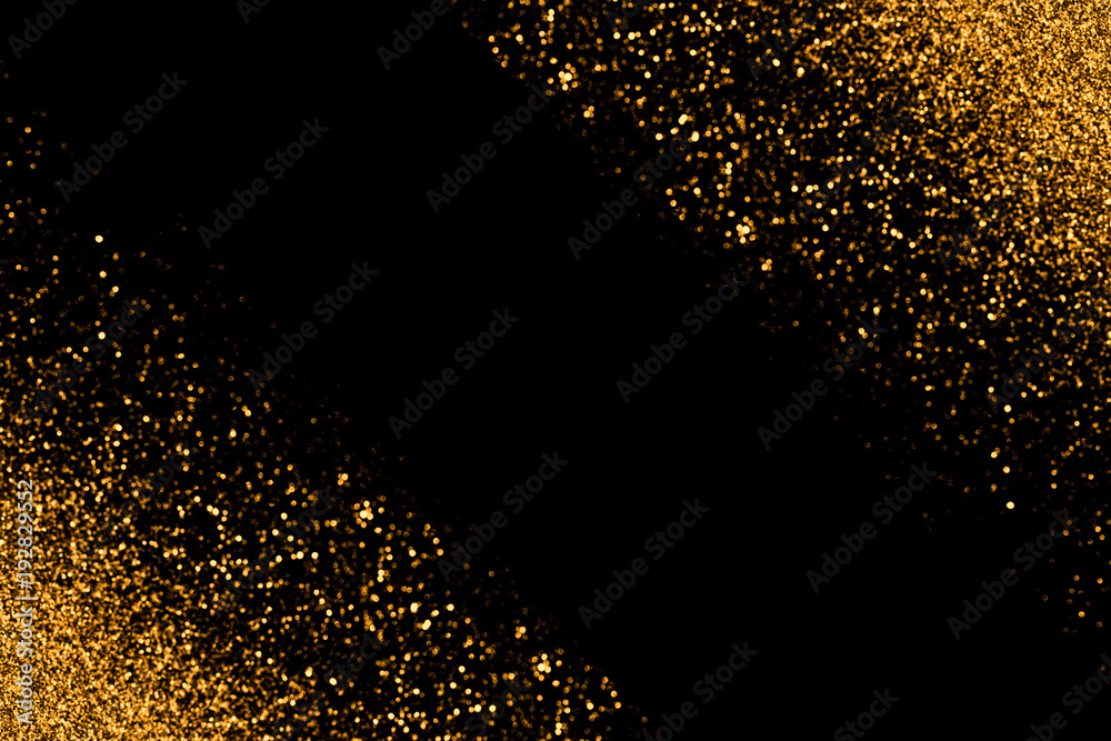 Defocused gold glitter with glowing sparks lights on a black background. Holiday greeting card Defocused gold glitter with glowing sparks lights on a black background. Holiday greeting card