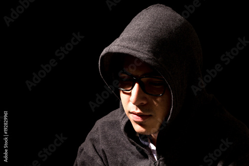 Hacker in a hood on dark background