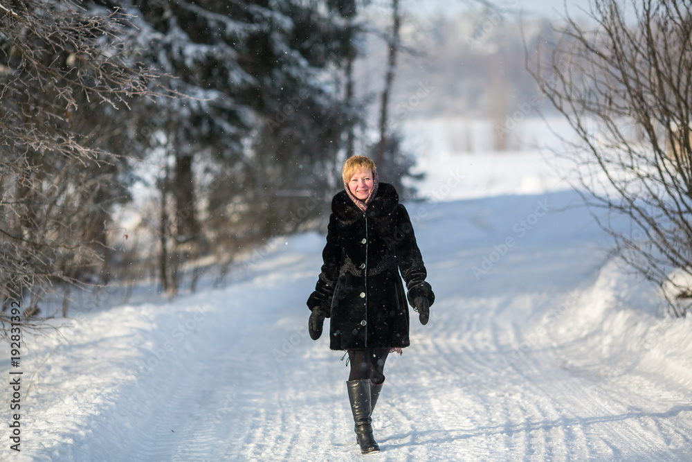 Young woman in the winter on the snowy road at park. Young woman in the winter on the snowy road at park.