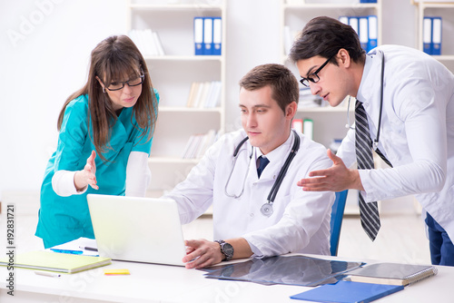 Three doctors discussing scan results of x-ray image