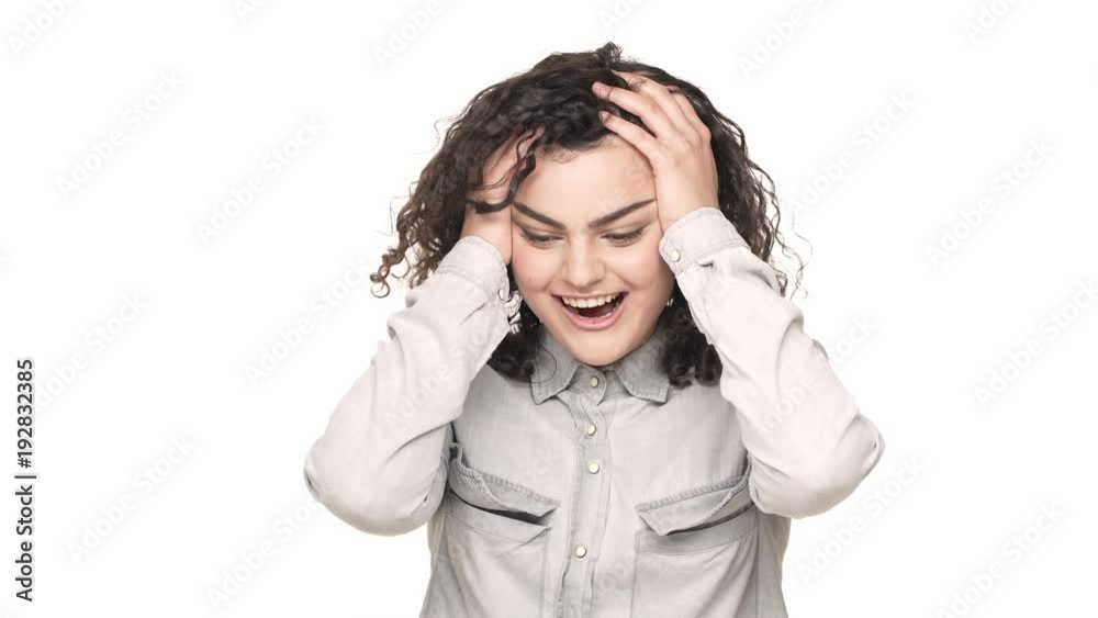 Portrait of surprised joyful woman with curly hair touching her head, and not believe in her happiness or victory over white background. Concept of emotions Portrait of surprised joyful woman with curly hair touching her head, and not believe in her happiness or victory over white background. Concept of emotions