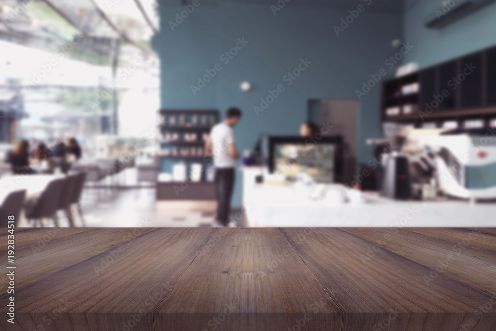 Wood table on blur of man in front coffee shop background