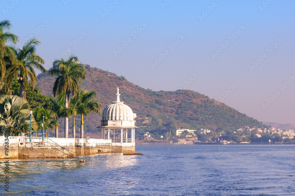 Nehru island on fateh sagar lake in Udaipur india. The white domes and trees of the island are visible. The green hills and blue water make this a perfect tourist place