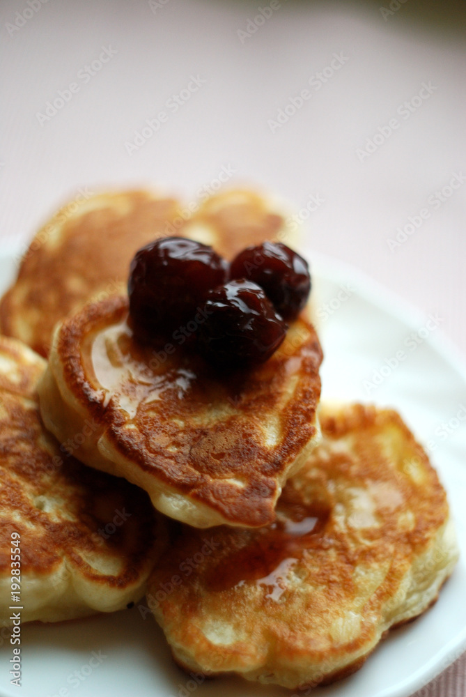 Thick russian pancakes piled on neutral background.