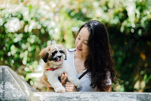 Photography Image of a beautiful Asian woman carrying her dog Shih Tzuh