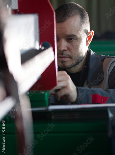 Portrait of electrician on overalls is working with energy panel and machinery equipment on plant photo