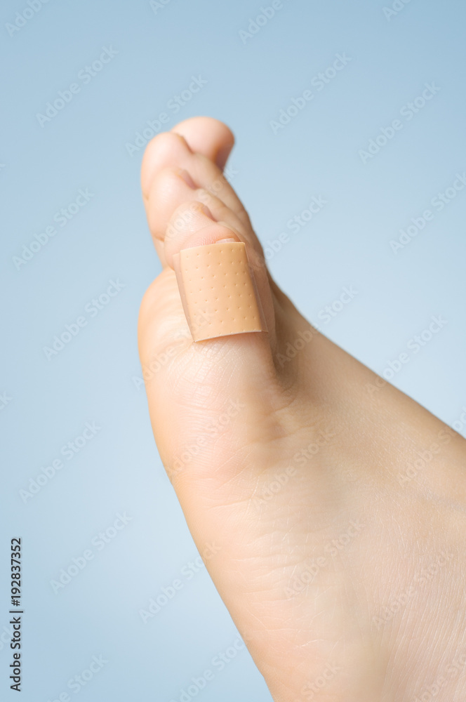 Closeup of a plaster on female toe Closeup of a plaster on female toe