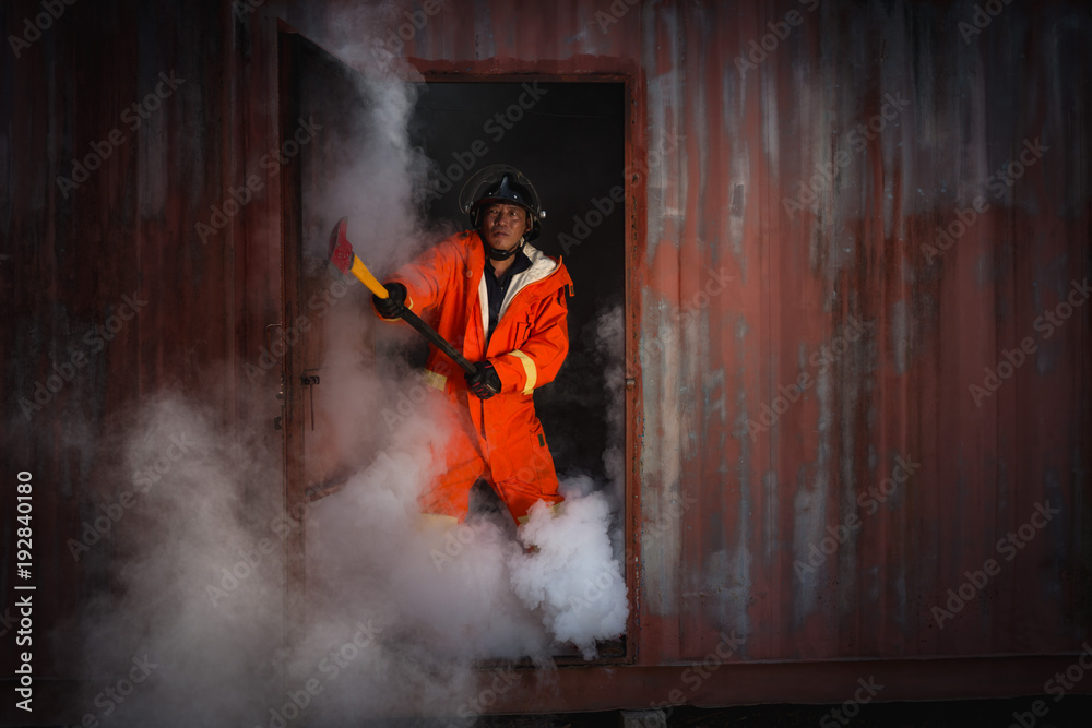 Obraz premium Firefighters training, Team practice to fighting with fire in emergency situation. A fireman run out from burnt place