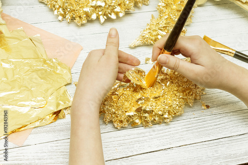 Cuadro en lienzo Gilding process. Female hands with a brush. Gold leaf