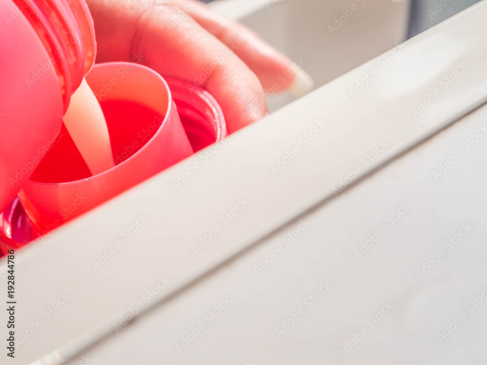 Woman flow fabric softener into the cap for laundry processing. Woman flow fabric softener into the cap for laundry processing.