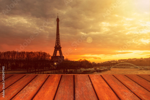 Empty wooden floor and Eiffel tower landscape view on sunset. © Khritthithat