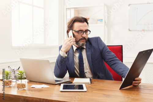 Serious businessman talking on mobile phone