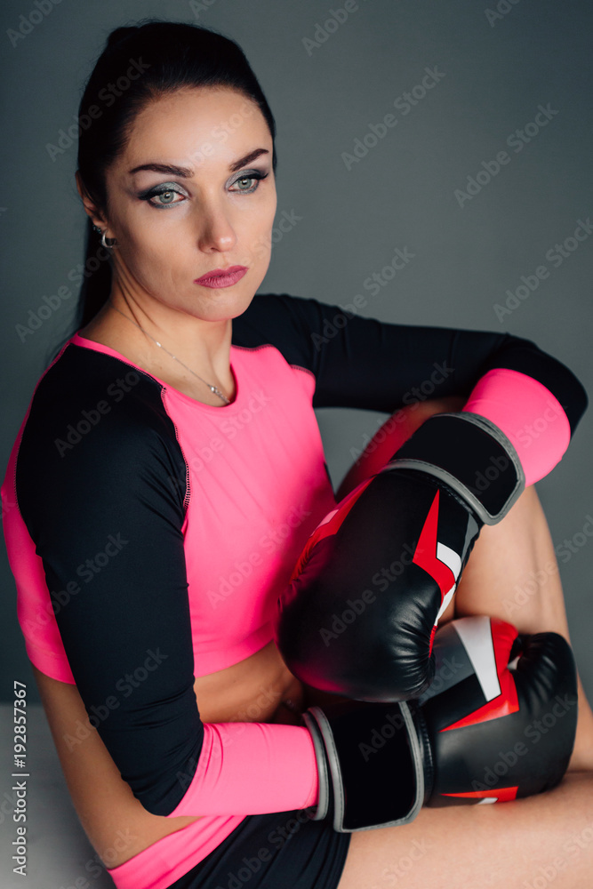 Close up portrait of a young sportswoman in boxing gloves. Pretty female brunete boxer. Healthy lifestyle concept. Girl fighter. Close up portrait of a young sportswoman in boxing gloves. Pretty female brunete boxer. Healthy lifestyle concept. Girl fighter.