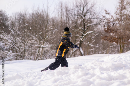 Little boy runs through snow
