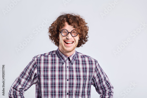 Canvastavla Curly nerd man in glasses with a stupid kind of funny emotion on a gray background