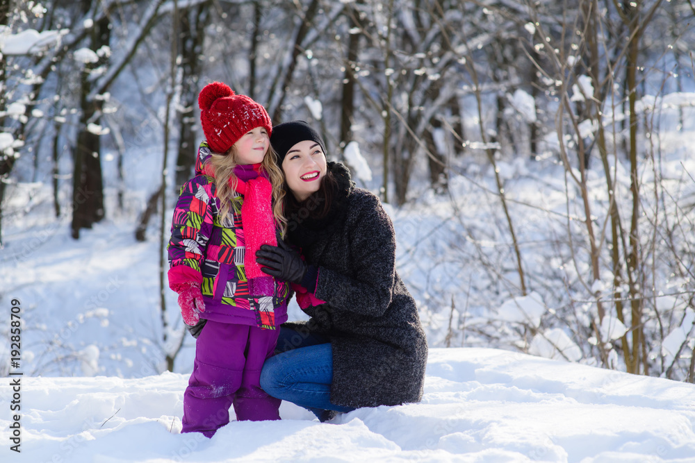 Girl and woman looking at something in winter forest Girl and woman looking at something in winter forest