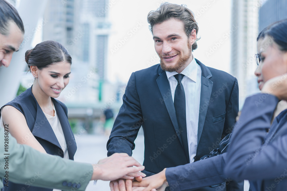 Professional business team joining stack hands and show hands together corporate meeting teamwork in cityscape background Professional business team joining stack hands and show hands together corporate meeting teamwork in cityscape background