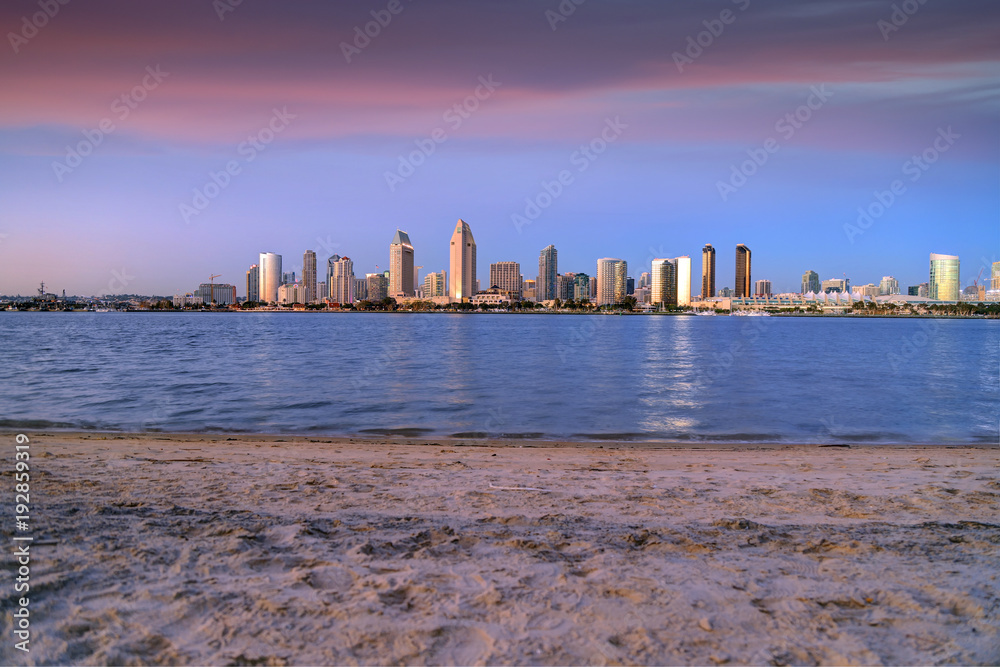 Naklejka premium The sunset over the San Diego skyline across San Diego Bay from Coronado Island.