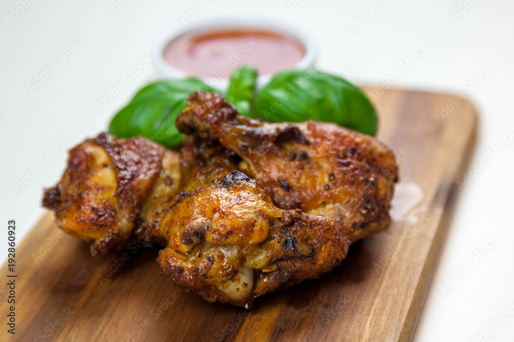 Chicken wings with sweet chilli sauce on the wooden cutting board Chicken wings with sweet chilli sauce on the wooden cutting board