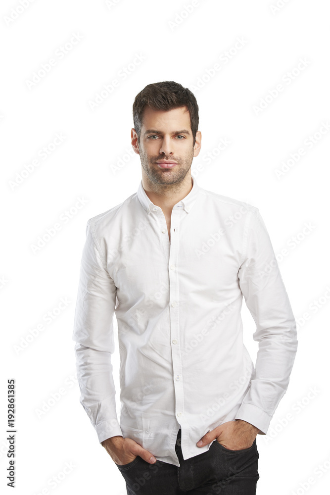 Young man portrait. Relaxed young businessman wearing shirt while standing against at isolated white background with copy space. 