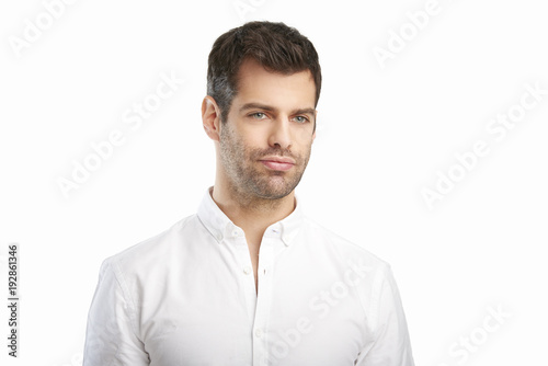 Young man portrait. Relaxed young businessman wearing shirt while standing against at isolated white background with copy space.  © sepy