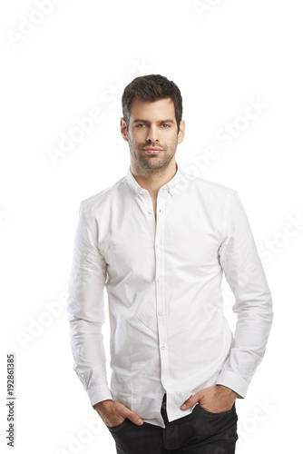 Young man portrait. Relaxed young businessman wearing shirt while standing against at isolated white background with copy space.  © sepy