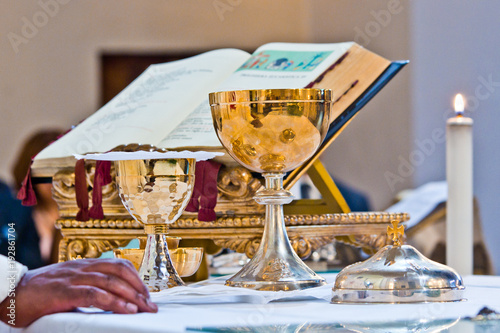 pisside and chalice contain wine and hosts on the altar of the mass