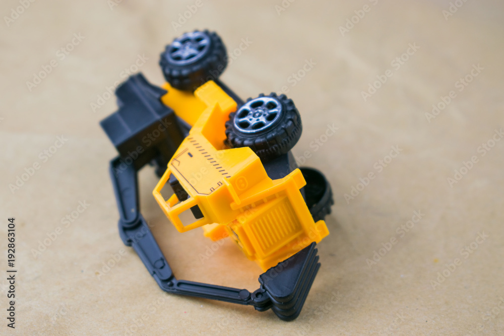 Obraz premium Construction machinery. Inverted toy excavator.