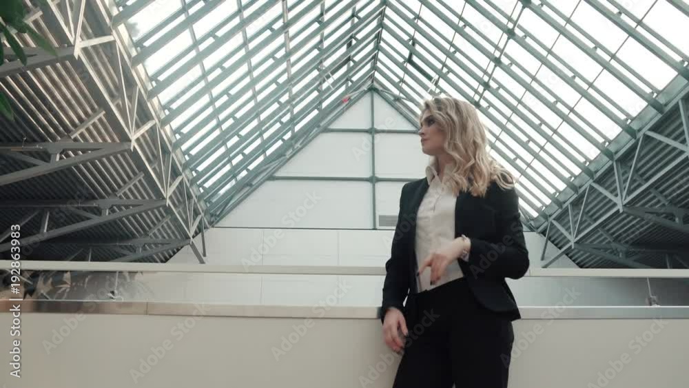 a business woman does not wait patiently for a business partner or client in the lobby of a modern office building a business woman does not wait patiently for a business partner or client in the lobby of a modern office building