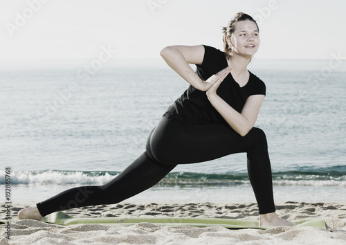 Adult female in black T-shirt is practicing yoga