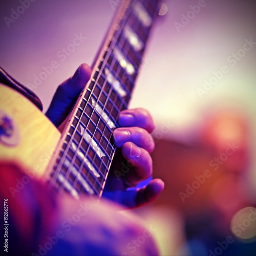 Guitarist plays electric guitar on stage with vintage effect photo