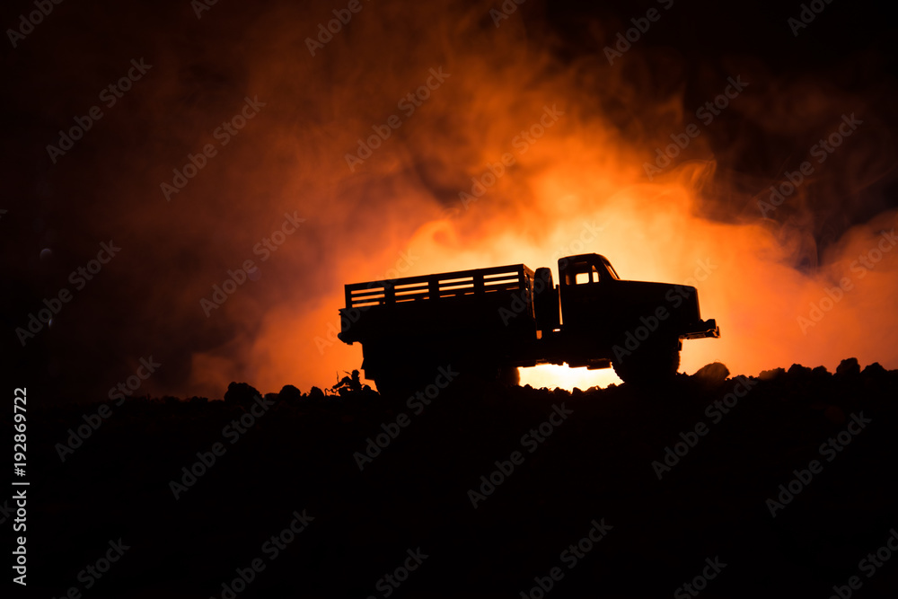 Fototapeta premium War Concept. Military silhouettes fighting scene on war fog sky background, World War Soldiers Silhouettes Below Cloudy Skyline At night. Attack scene. Armored vehicles.
