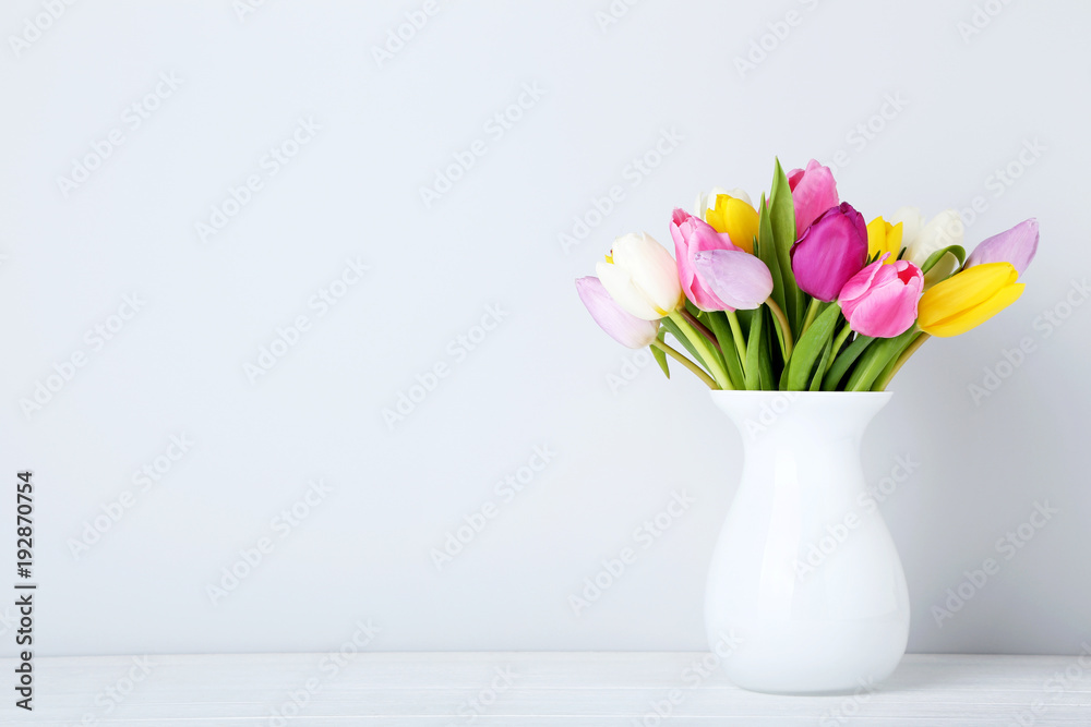 Bouquet of tulips in vase on wooden table