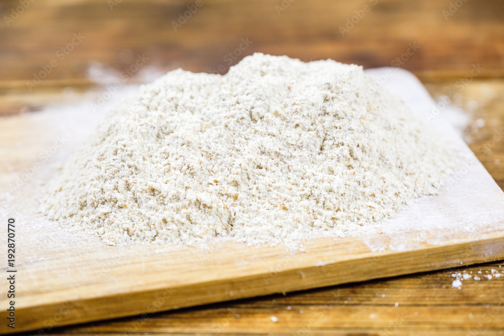 Close-up heap with rye flour coarse on a wooden board. Close-up heap with rye flour coarse on a wooden board.