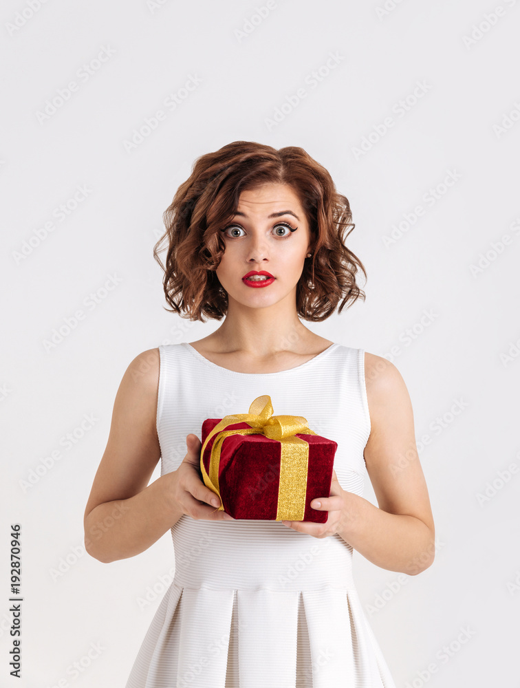 Beautiful young girl receives a gift, surprised Beautiful young girl receives a gift, surprised