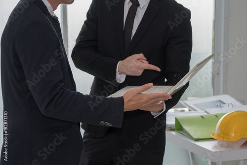 Business man standing and discussing to point work detail shown in laptop