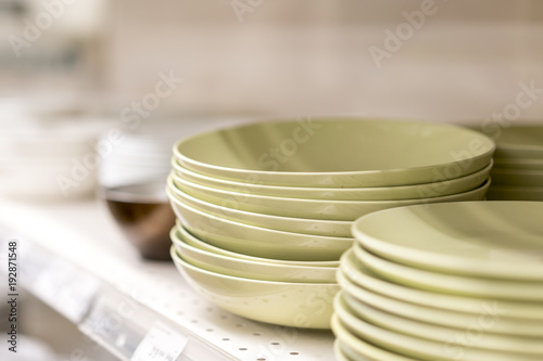 Olive-colored flat dishes on the shelf in the store
