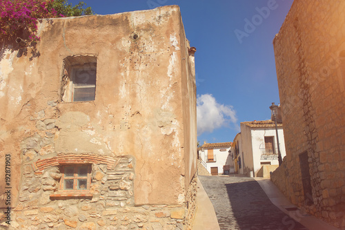 Small european village street under the sun with flowers