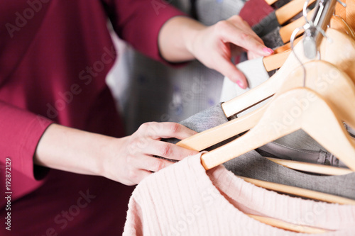 Closeup shot of hands of woman who choosing new clothes, fashion shop concept
