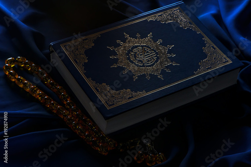 Holy islamic book Koran on the draped table with a rosary. Ramadan Kareem beautiful poster, banner, postcard for the celebration of the festival of the Muslim community photo