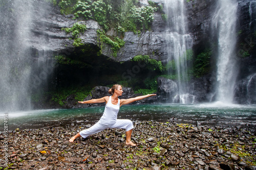 Woman practices yoga near Sekumpul waterfall in Bali  Indonesia