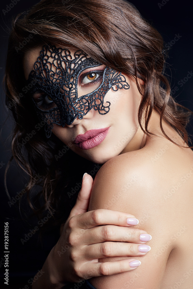 Mysterious girl in a black mask, masquerade. Sexy Nude brunette woman with  curly hair on a black background in the mask on the face Stock Photo |  Adobe Stock