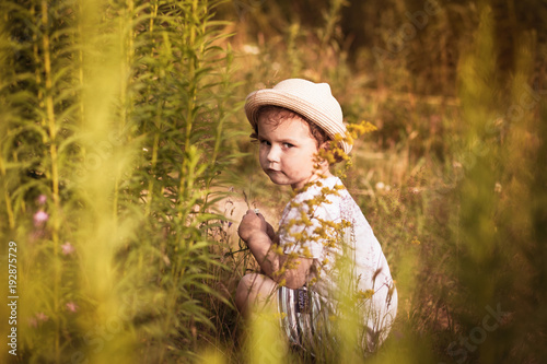 little girl is playing on nature in summer 