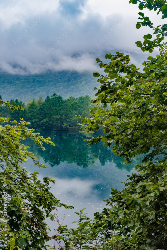 Obraz premium Blue karst lake, reflection of green foliage on the water